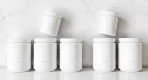 A professional arrangement of eight plain supplement canisters on a marble surface for our 8 best maca root powder for libido guide.